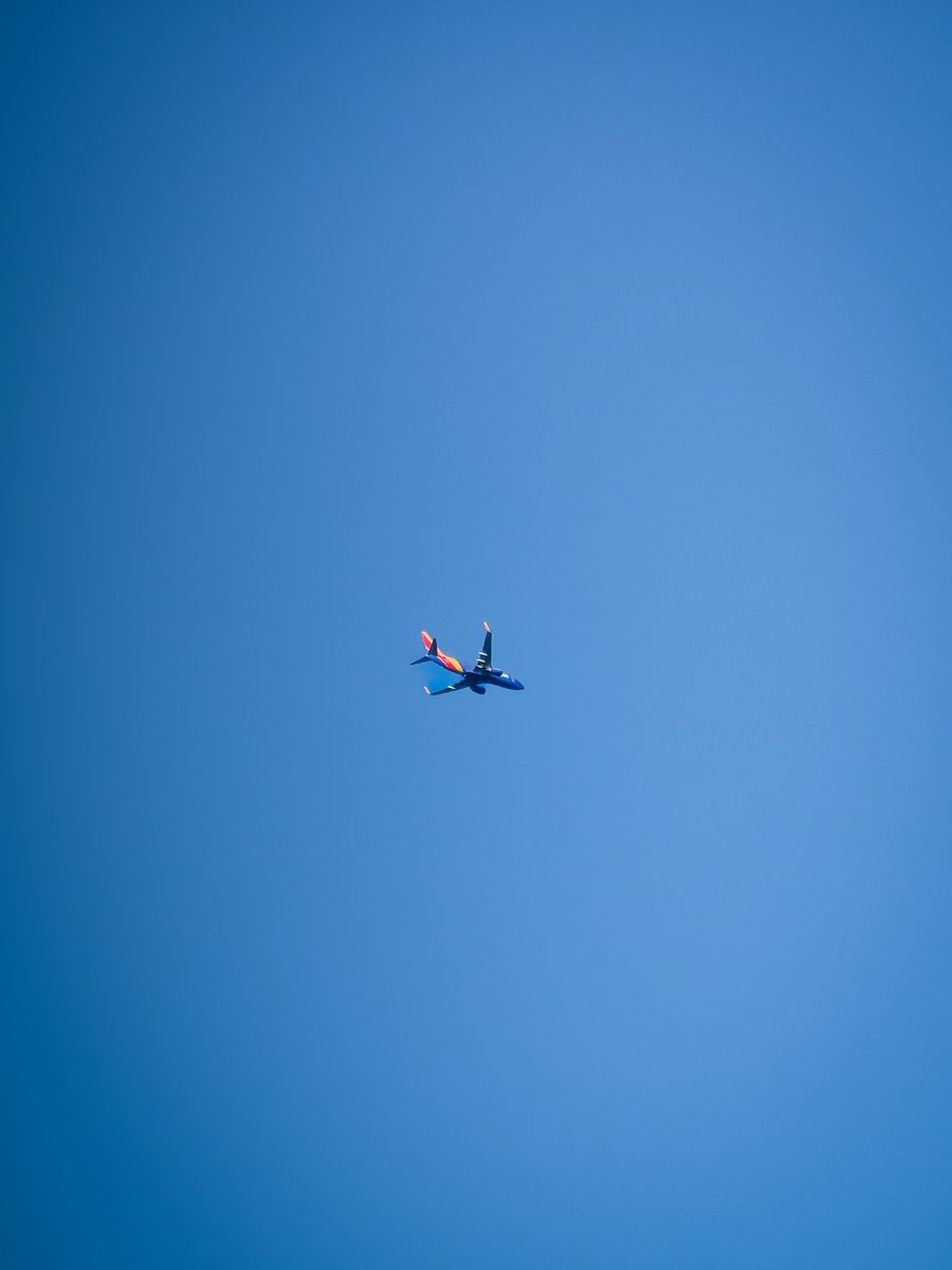 A commercial jet flying against a clear blue sky